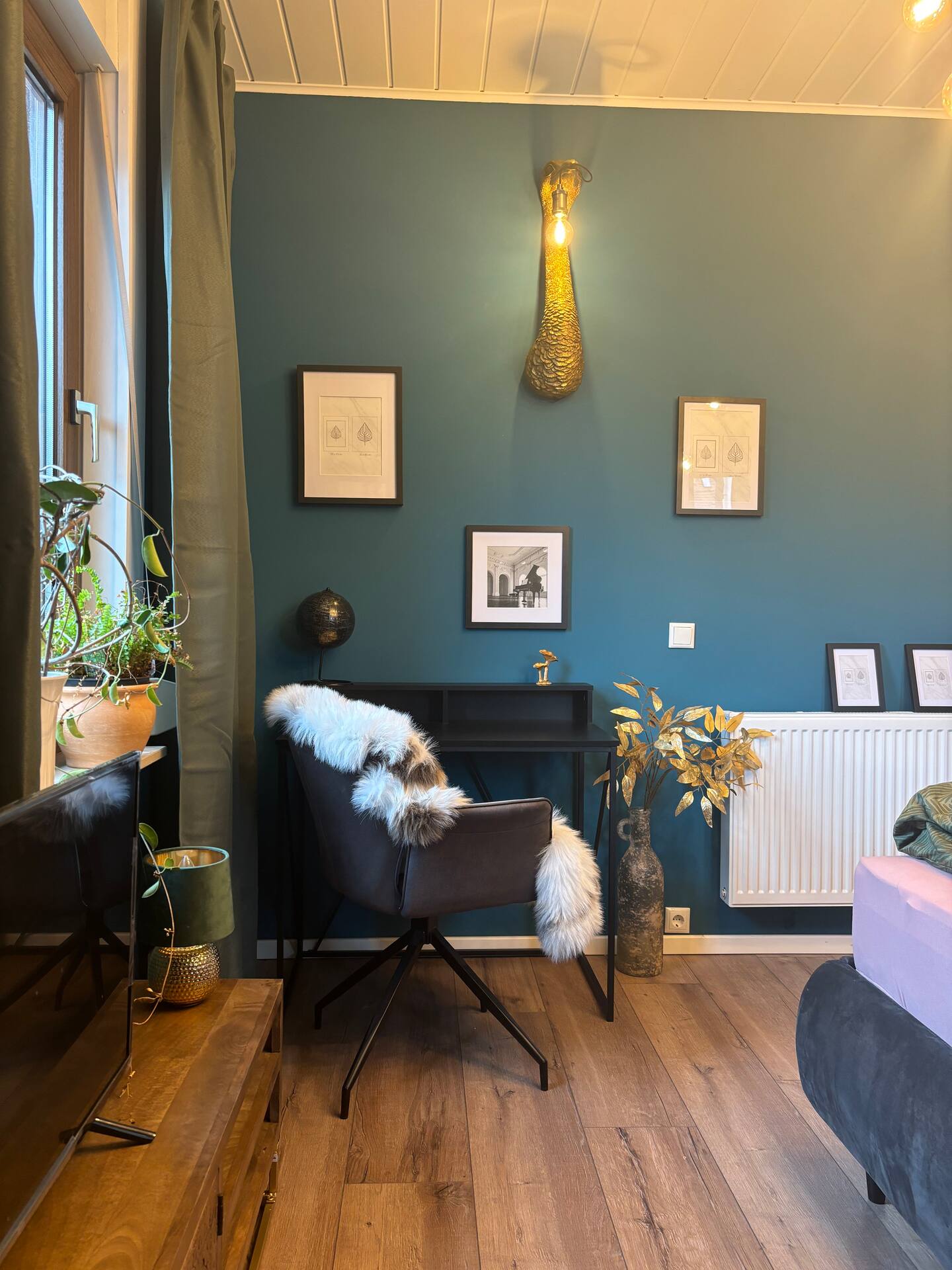 Arbeitsplatz vor der petrolfarbenen Wand im Gästezimmer